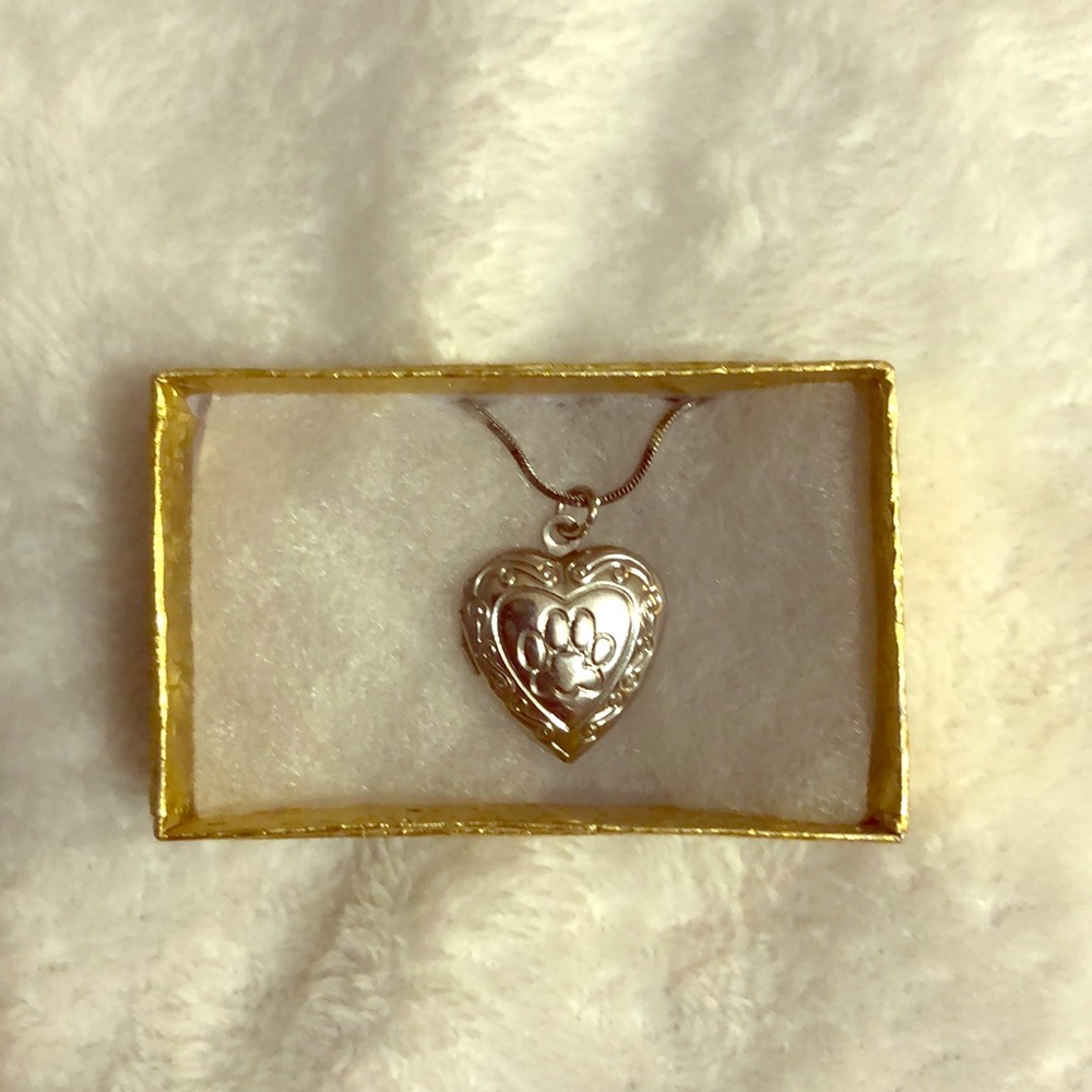 A paw print, heart-shaped locket